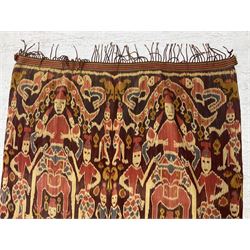 Ikat Man’s Cloth (Hinggi Kombu), East Sumba, Indonesia, woven in red, blue and yellow-brown warp ikat, constructed of two mirroring long panels, the motifs arranged in four bands depicting warrior figures astride rearing horses, high-ranking figures and guardians within geometric borders, on carved wooden wall hanger, L295cm

