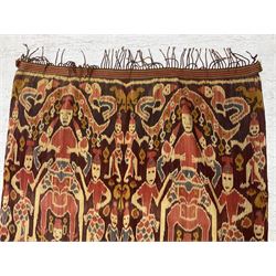 Ikat Man’s Cloth (Hinggi Kombu), East Sumba, Indonesia, woven in red, blue and yellow-brown warp ikat, constructed of two mirroring long panels, the motifs arranged in four bands depicting warrior figures astride rearing horses, high-ranking figures and guardians within geometric borders, on carved wooden wall hanger, L295cm
