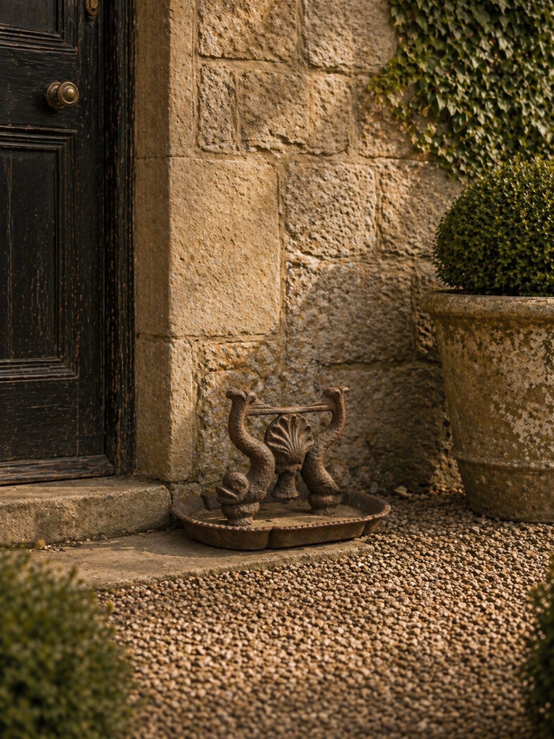 Victorian cast iron boot scraper, supported by two dolphins with central shell motif