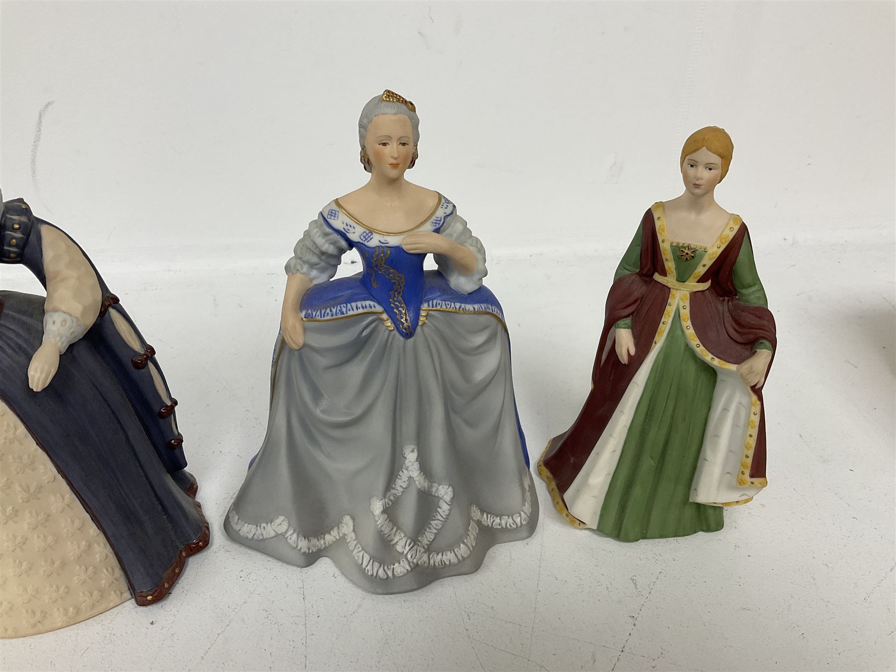 Four limited edition Franklin Mint figures of queens comprising Elizabeth I, Isabella of Spain, Catherine the Great and Marie Antoinette