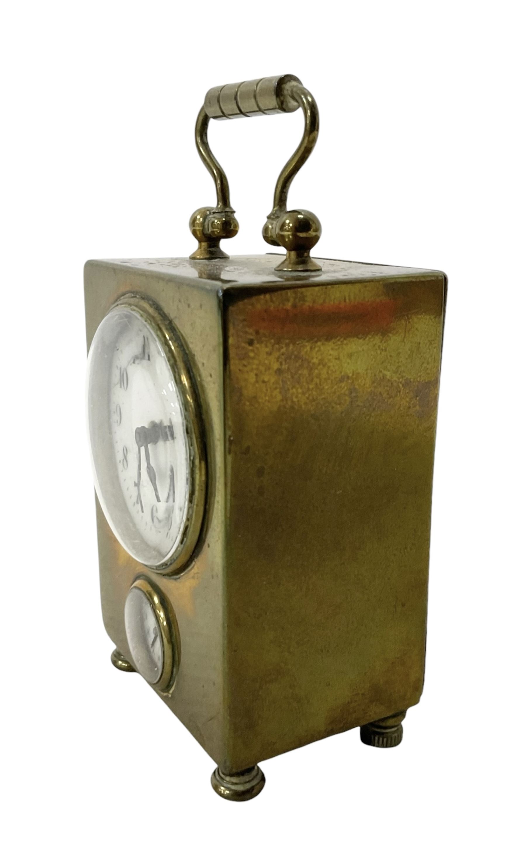 French - petite early 20th century French brass cased travelling alarm clock, with bun feet and carrying handle, circular enamel dial with Arabic numerals and spade hands, conforming alarm setting dial beneath, with a platform escapement, wound and set from the rear.