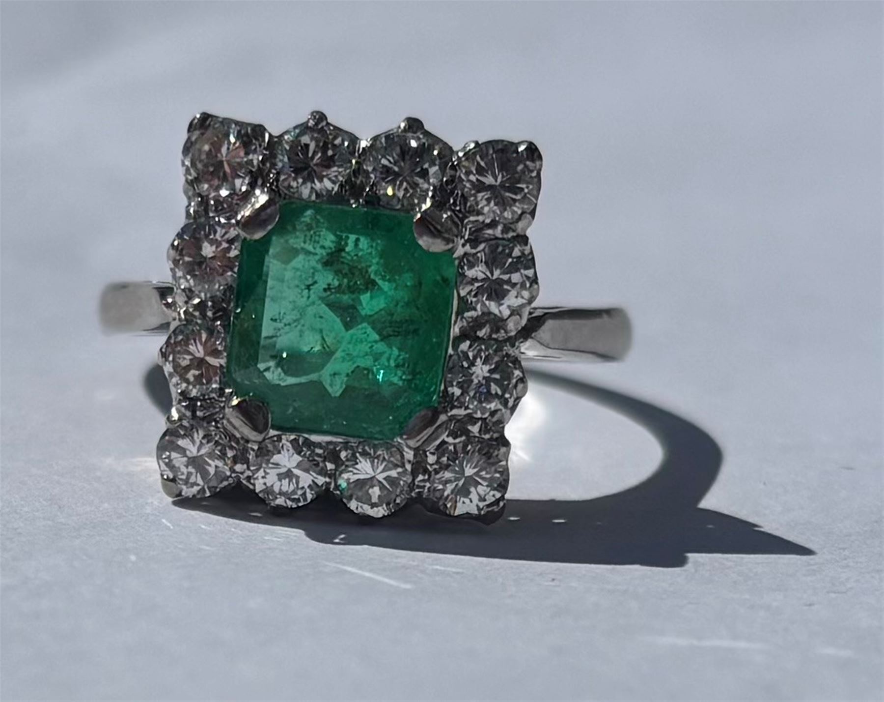 18ct white and yellow gold emerald and diamond cluster ring, single octagonal cut emerald of approx 1.55 carat, surrounded by twelve round brilliant cut diamonds, total diamond weight approx 0.95 carat