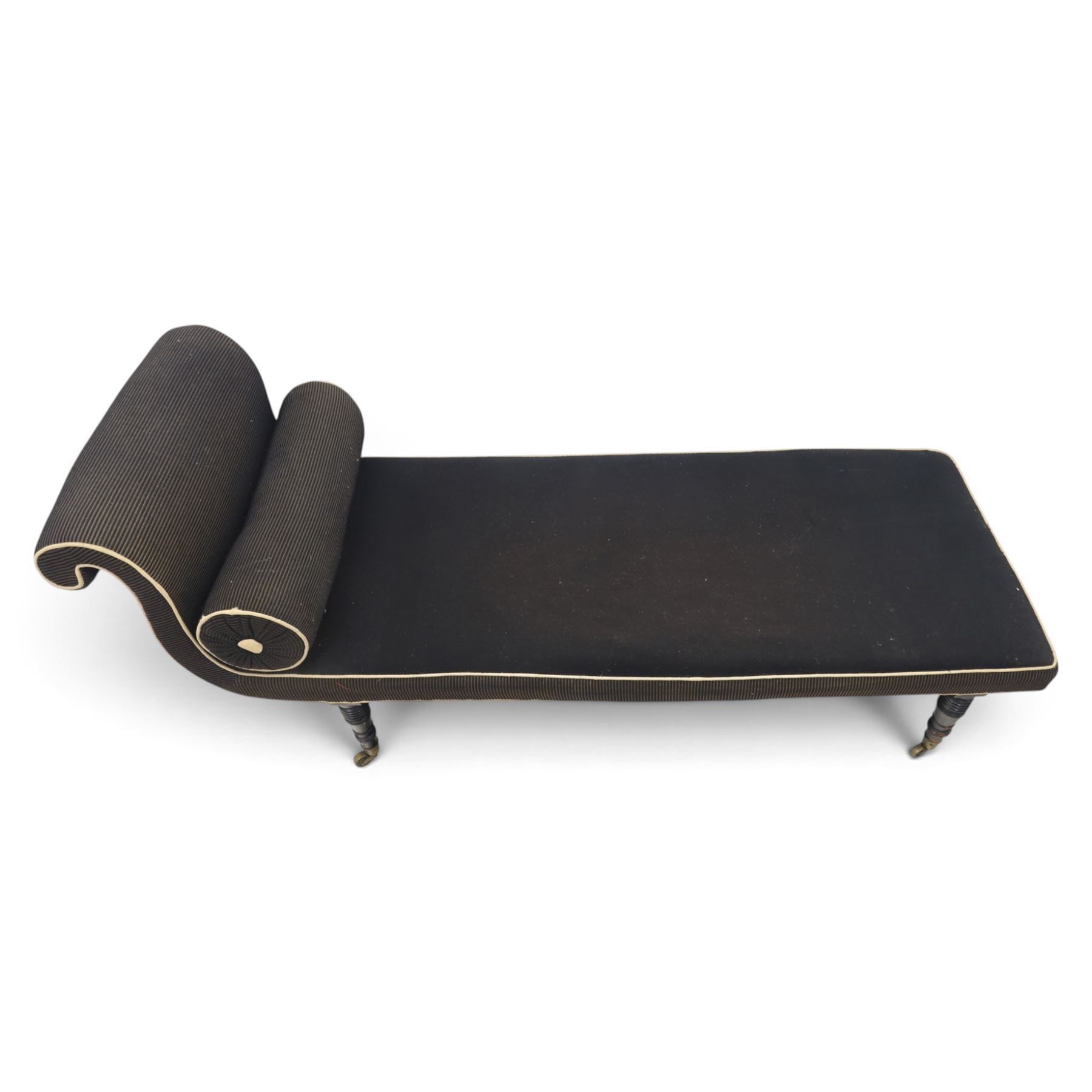 Victorian ebonised chaise longue, upholstered in black fabric with scroll headrest and bolster cushion, rectangular seat with rounded corners, raised on turned supports terminating in brass and ceramic castors