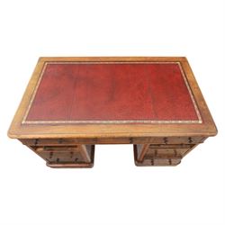 Victorian mahogany writing desk, featuring inset tooled red leather top, raised on two pedestals, nine drawers with figured veneer fronts