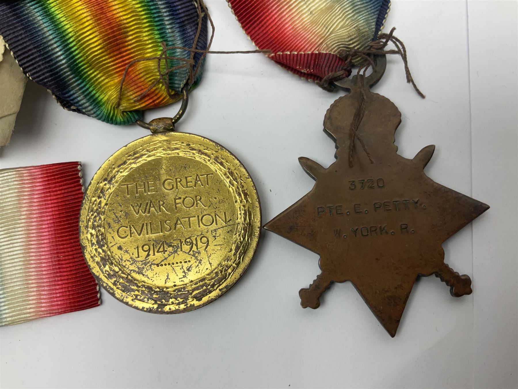 WWI pair of medals comprising British War Medal and Victory Medal awarded to 32682 Pte. W. Meadows W. Rid. R. in issue box; WWI pair of medals comprising 1914-15 Star and Victory Medal awarded to 3720 Pte. (later Cpl.) E. Petty W. York. R. with issue letter from Tank Corps; WWII group of five medals comprising 1939-45 War Medal, Defence Medal and 1939-45, Italy and Africa Stars; all with ribbons; and book of nineteen seaman's Certificates of Discharge to cook Charles Filburn 1893 - 1901 from various British ports