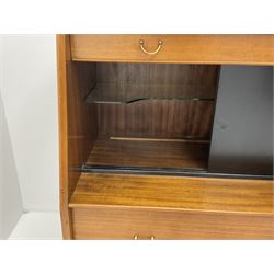 1950s G-Plan retro highboard unit, single long drawer above glazed sliding doors enclosing shaped glazed shelve, alongside a fall front door, above one short and one long drawer, raised on outsplayed tapering supports 