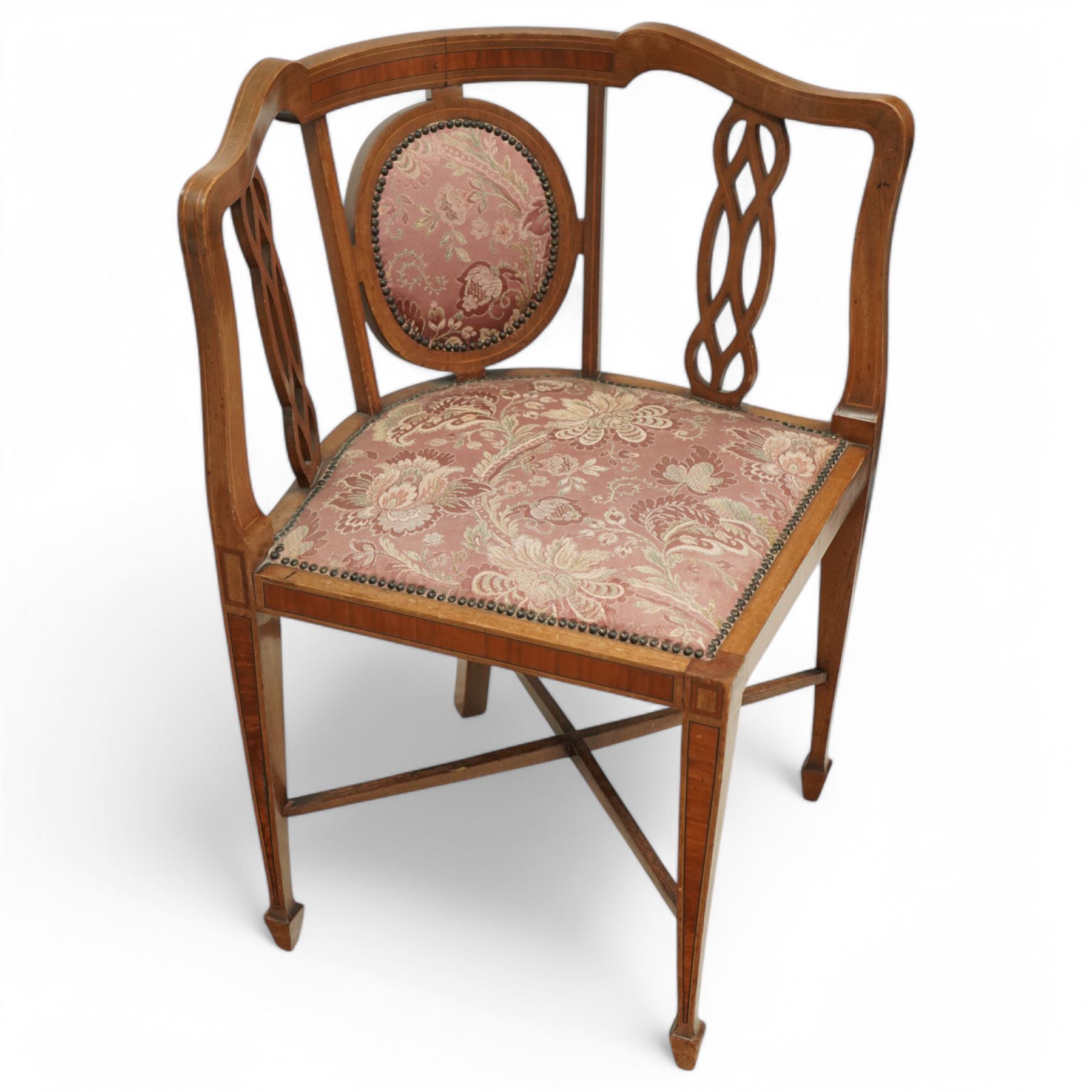 Edwardian inlaid mahogany corner chair, shaped cresting with satinwood band over interlaced splats, upholstered in floral pattern fabric, on square tapering supports with spade feet united by X-stretcher 