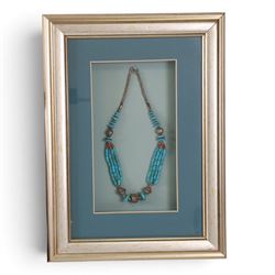 Four framed pieces of jewellery, including tribal coin and blue stone choker, multi stand necklace with turquoise beads and two box pendants 
