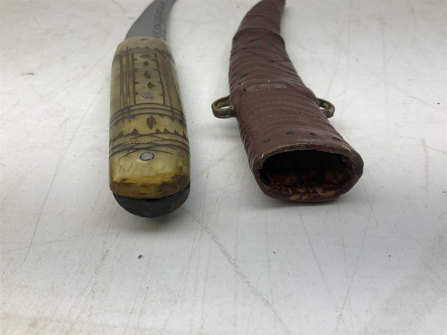 Caucasian qama or kindjal dagger, the 15cm pointed double edged blade with centre fuller and two-piece horn grip;  in nickel plated scabbard with panels of figures and script L28.5cm overall; and eastern knife with 20.5cm curving blade and decorative horn grip; in leather covered scabbard (2)