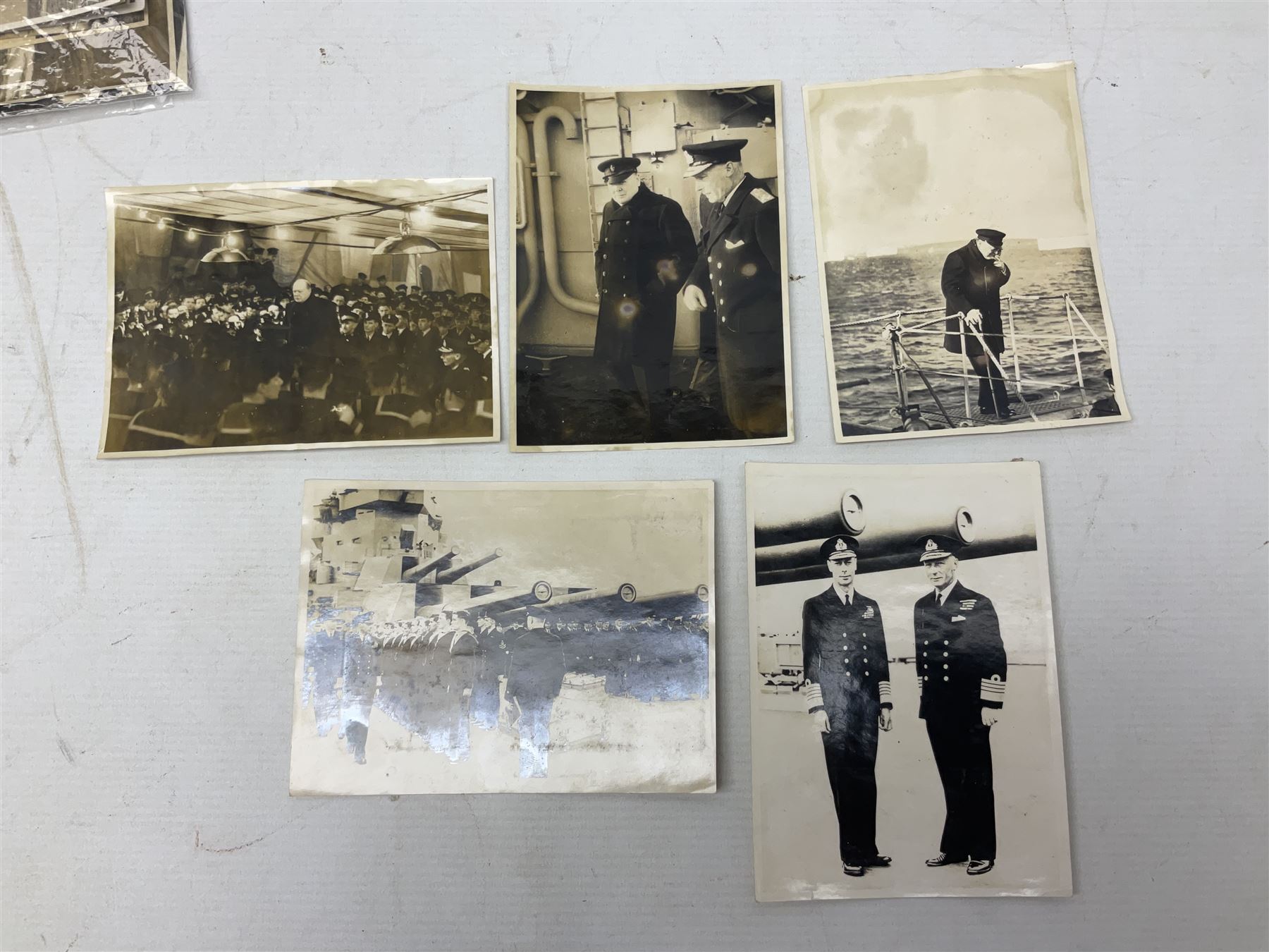 Disbound WW2 album relating to the battleship HMS King George VI containing over fifty various size loose photographs of the ship in action, guns firing, crew members, aircraft, two of George VI on board, three of Winston Churchill on board, official 1942 Christmas messages including Franklin Roosevelt etc; together with unrelated printed letter on 10 Downing Street notepaper from Winston Churchill; and Order of Service for Churchill's funeral at St. Paul's Cathedral 30th January 1965