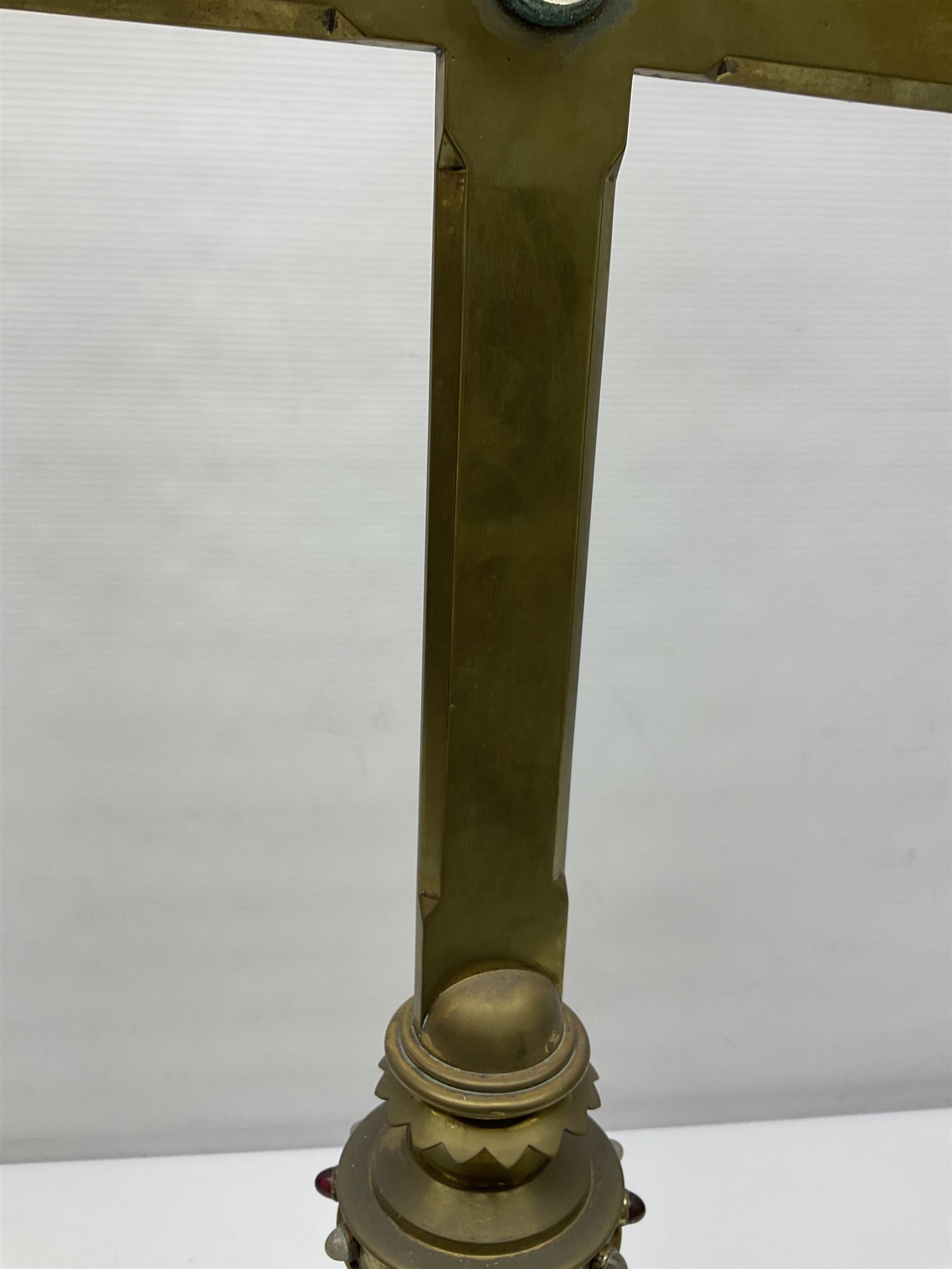 Brass alter cross, decorated with glass cabochons, upon a acicular stepped base and three claw feet, H73cm 