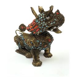 A 20th century Chinese filigree brass model of a Foo Dog, with  turquoise and coral roundels and lozenges, H11.5cm. 