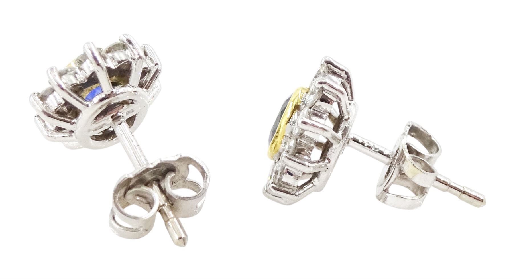 Pair of 18ct white and yellow gold oval cut sapphire and round brilliant cut diamond cluster stud earrings, London 1991, total sapphire weight approx 0.60 carat, total diamond weight approx 0.60 carat