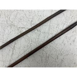 Native long-shafted spear, the large iron head with central medial ridge and decorative neck, on plain circular haft L260cm; and another similar Native long-shafted spear with cane haft L249cm (2)