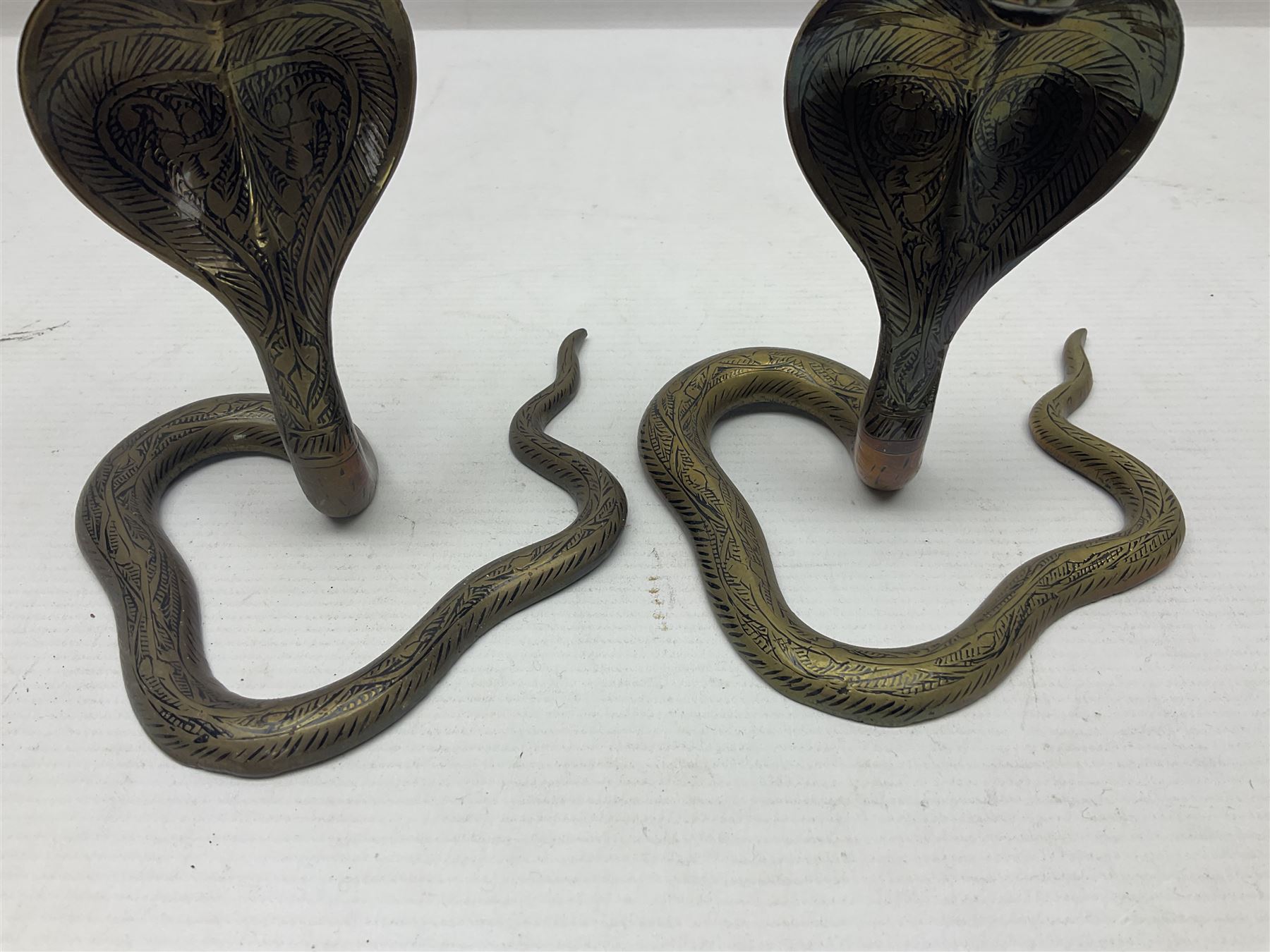 Indian brass pedestal dish, the dish engraved with peacock to centre, the stem modelled as a King Cobra, with engraved and enamelled decoration throughout, together with a similar pair of candlesticks, modelled as King Cobras, dish H23.5cm 