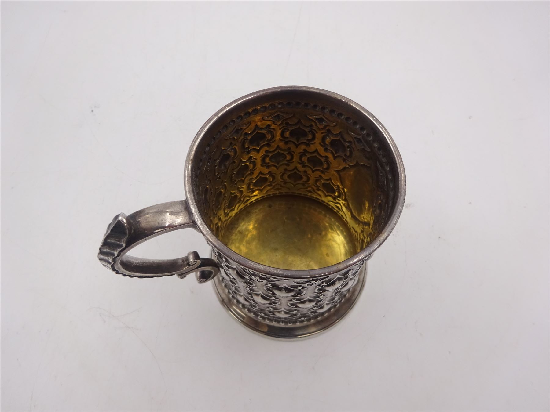 Victorian silver christening mug, with repousse and chased scroll and bead decoration, lozenge shaped cartouche engraved with monogrammed initials and acanthus capped C scroll handle, hallmarked Robert Hennell III, London 1861, H9.3cm