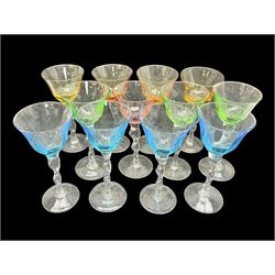 Ten coloured Adriana wine glasses by Abigails, to include blue, green, pink and yellow examples, each with part faceted bowl and twist stems, together with two similar orange examples with pulled stems, H24cm