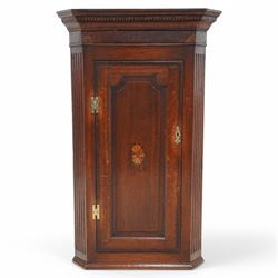 19th century mahogany corner wall cupboard, with projecting cornice and dentil moulding above a single door with shaped fielded panel and satinwood fan inlay, flanked by fluted pilasters, fitted with shaped interior shelving