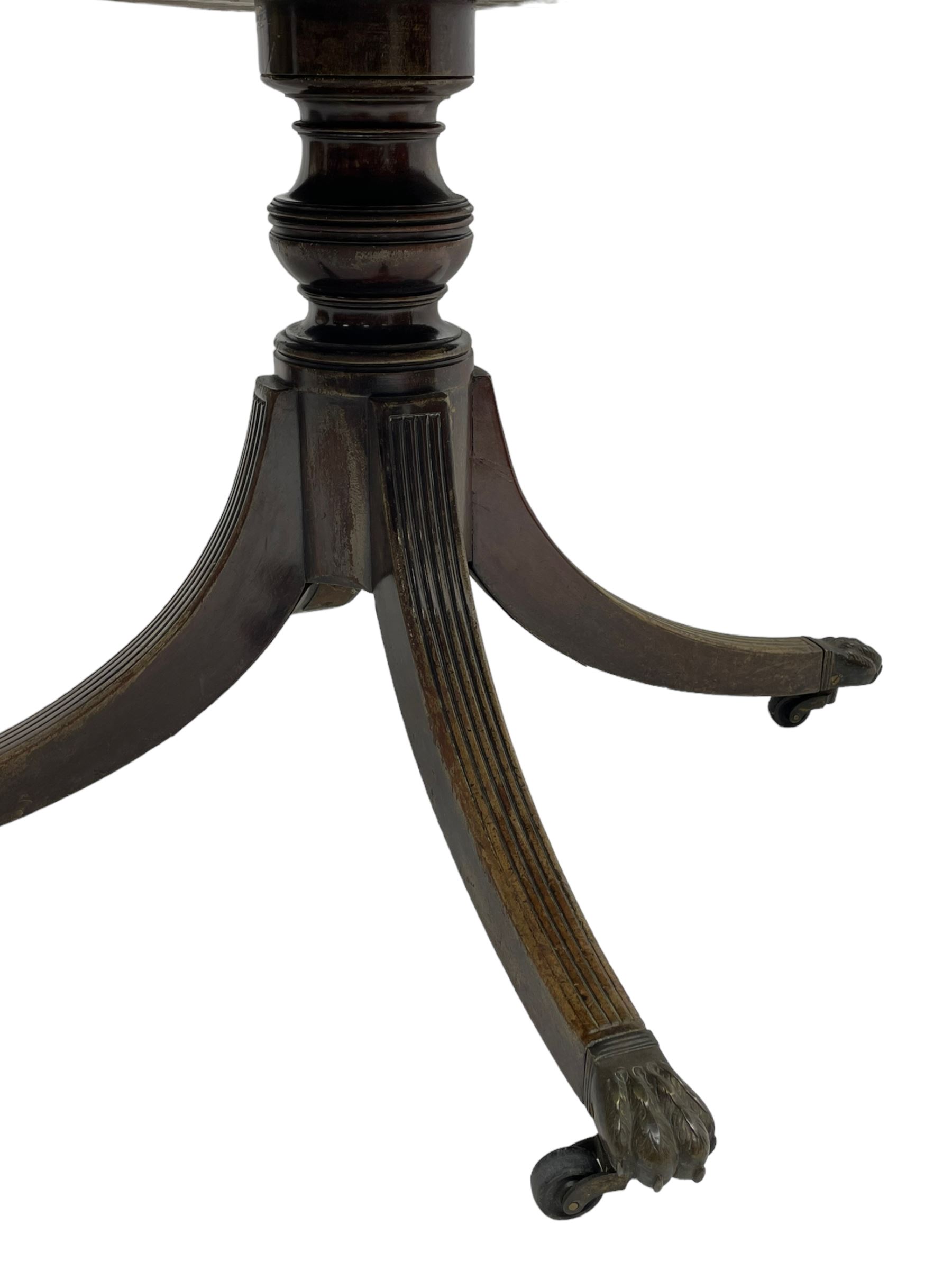 George III mahogany breakfast table, the oval top with a kingwood band and boxwood stringing, raised on a turned vasiform pedestal terminating in a fluted sabre tripod base with hairy paw feet and castors