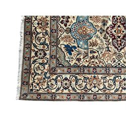 Persian Nain ivory ground rug, wool with silk inlay, the field decorated with stylised gul motifs with palmettes surrounded by interlacing foliate patterns, the guarder border decorated with repeating flower heads and scrolling vines