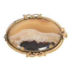 Six brooches, including one Ruskin example in silver mount, four Ruskin style brooches with ceramic roundels and a plated agate example