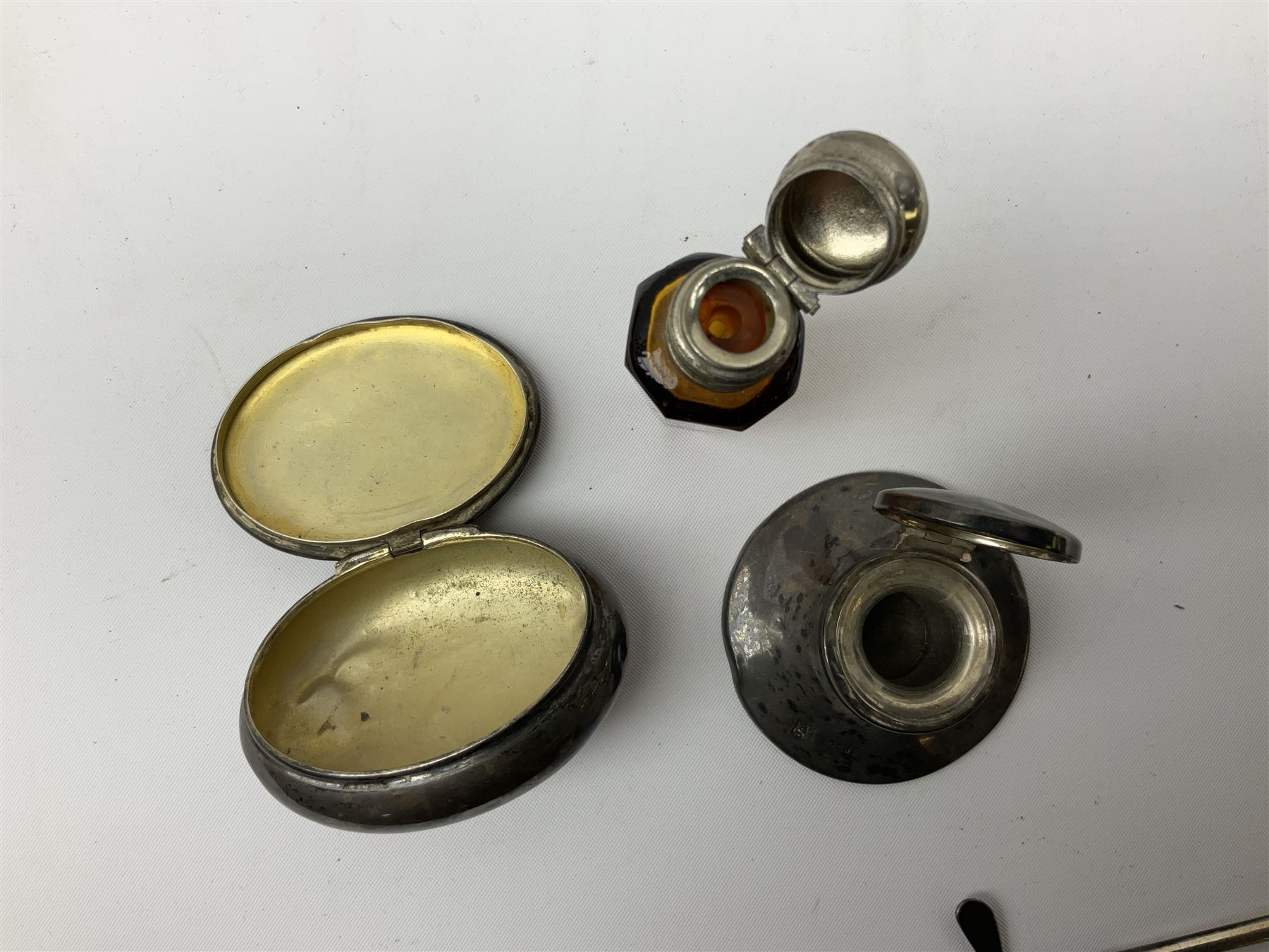 German silver pill box of oval form, the cover decorated with a serpent, stamped with crown and crescent and marked 800, together with a miniature silver capstan inkwell with glass liner, hallmarked Birmingham, a novelty silver teaspoon with golf club terminal, hallmarked Birmingham, and an amber glass scent bottle with silver plated cover, approximate weighable silver (not including inkwell or scent bottle with silver plated cover) 41.9 grams