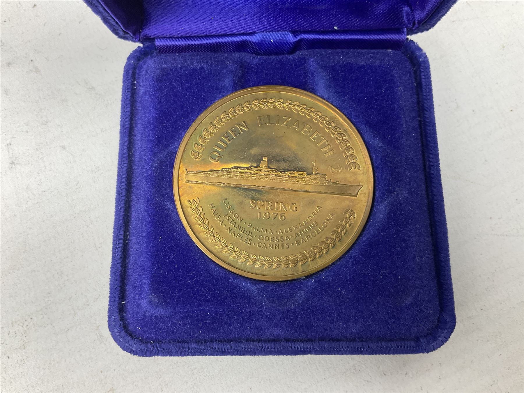 Queen Elizabeth II cradle of civilization cruise 1976 bronze medallion with related book and two other Queen Elizabeth II commemorative medallions for cruises in 1975 and 1976, all cased