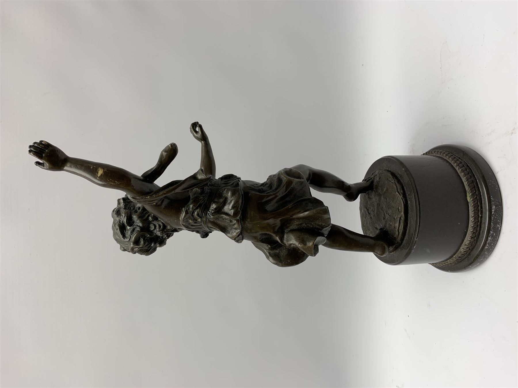After E Plat, bronze modelled as a dancing child, signed E. Plat, upon cylindrical black marble base, H40cm