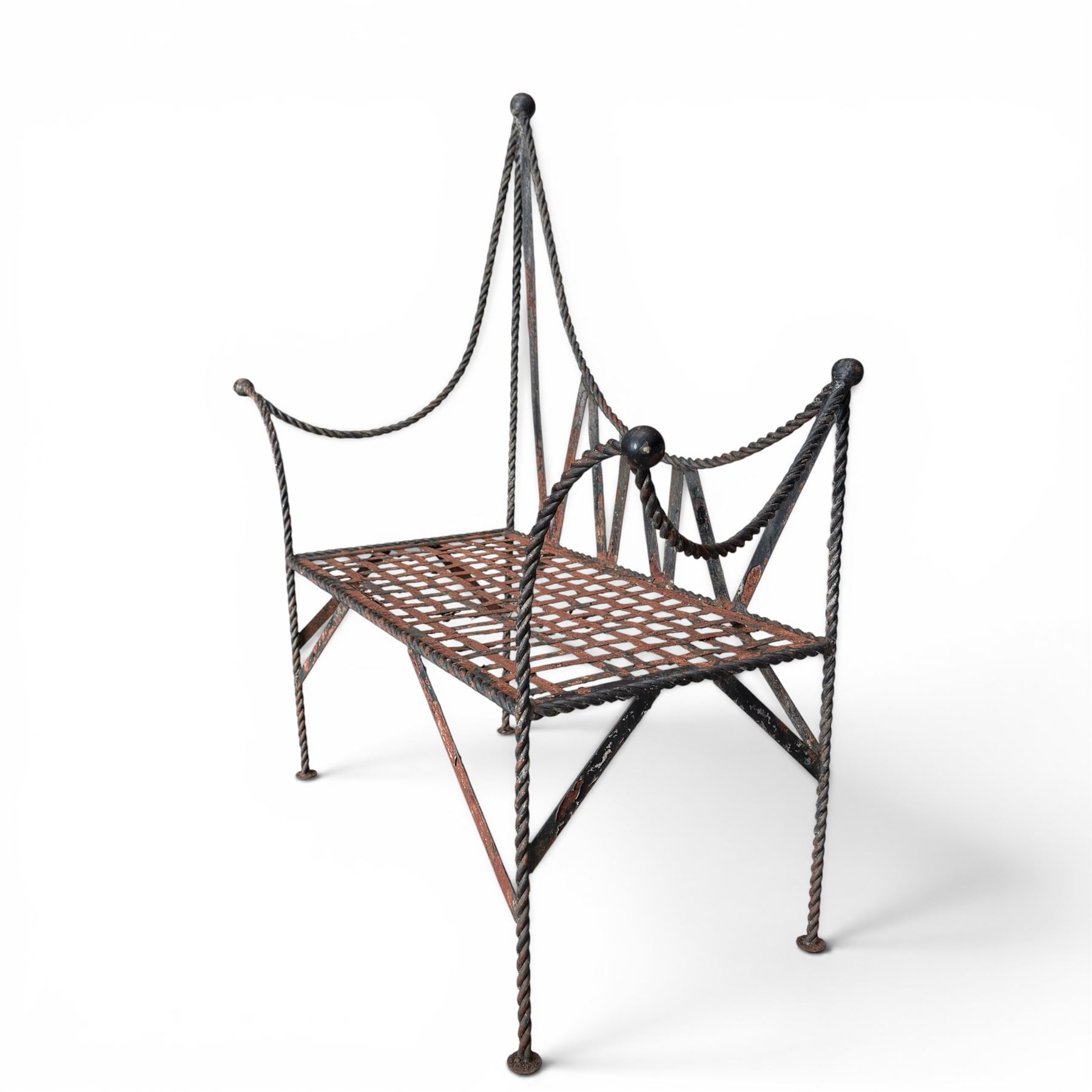 Victorian design wrought iron garden bench, with asymmetrical rope-twist frame, arched back and sides over out-swept arm terminals with ball finials, flanking a lattice seat, in antique black-painted weathered finish