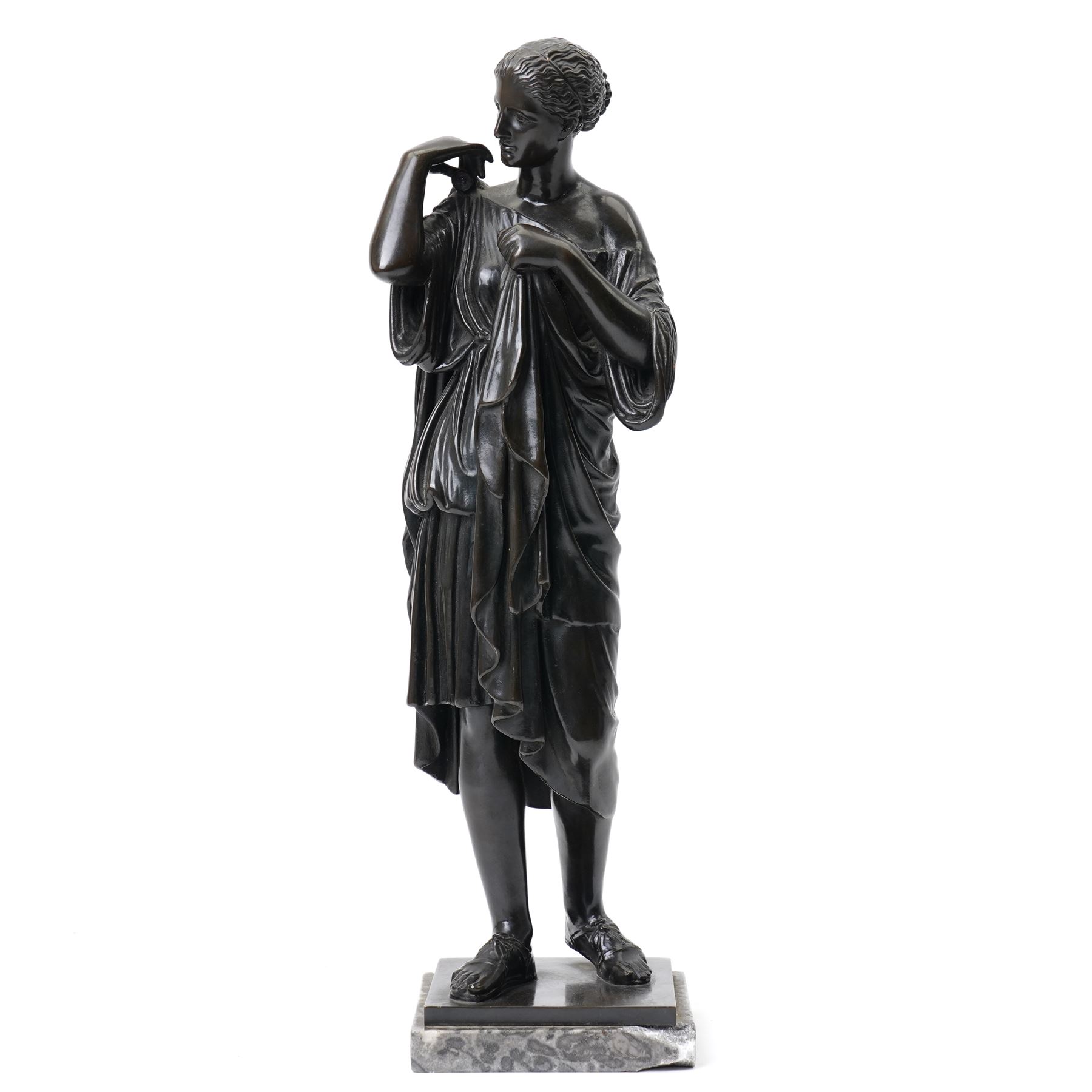 After the Antique - Grand Tour patinated bronze figure of a Vestal Virgin, the maiden standing in contrapposto, draped in classical robes and pinning her chiton at the shoulder and chest, on a square marble base stamped to rear, circa 1900, W15cm H47cm