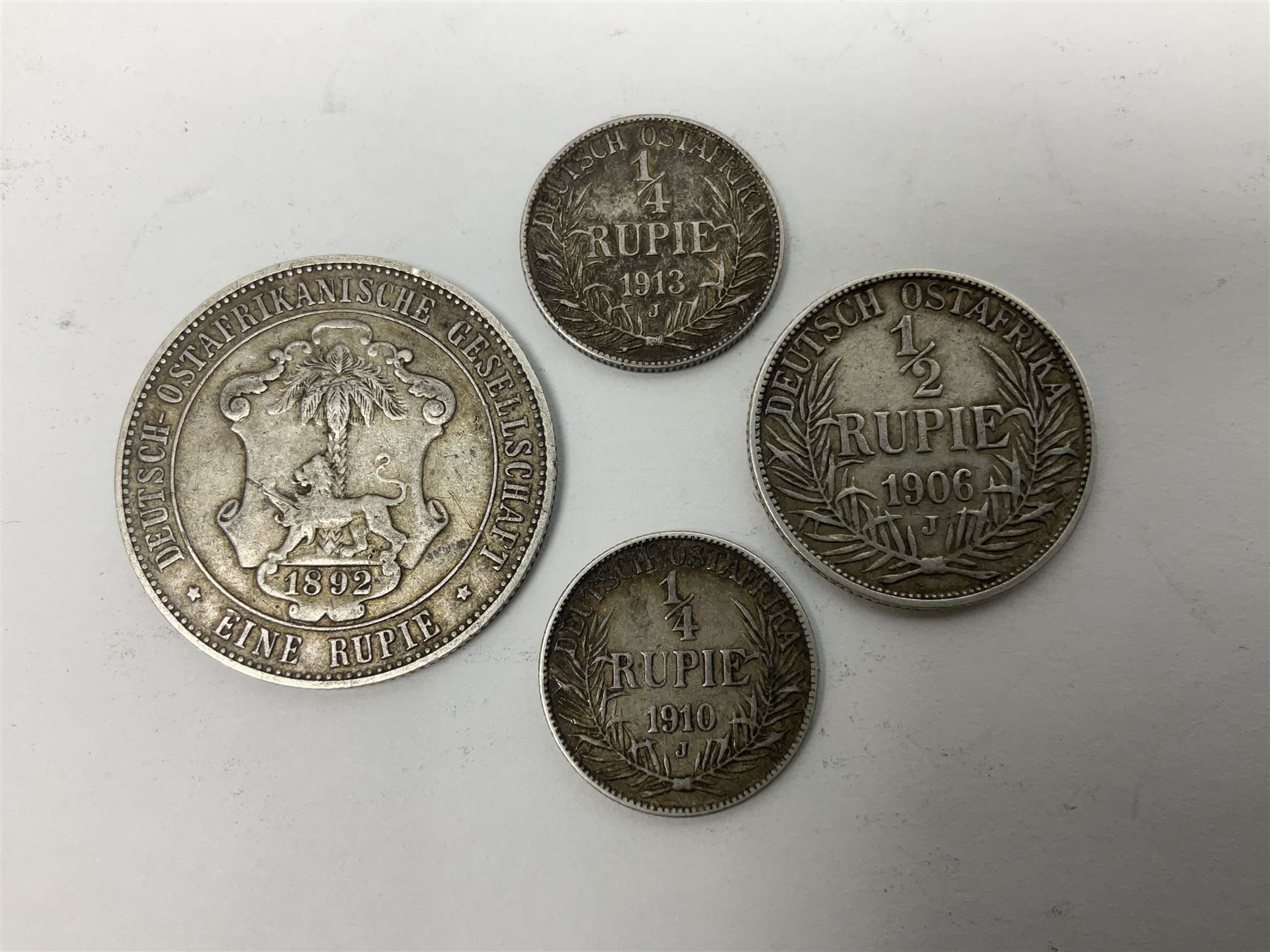 German East Africa 1892 one rupie, 1906 half rupie, and two quarter rupie coins dated 1910, 1913