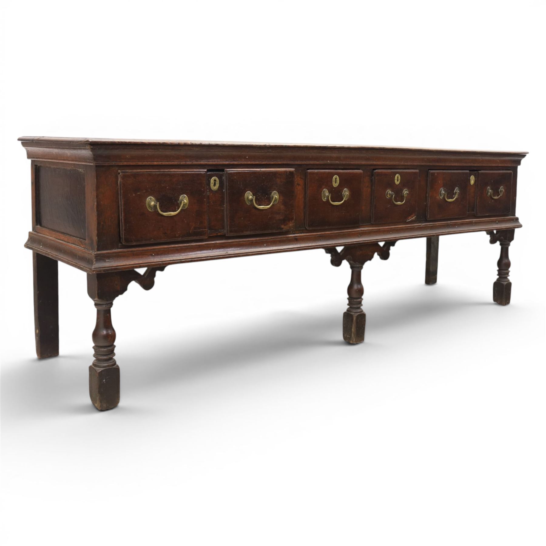 17th century 8’ oak dresser base with moulded front, rectangular top, above four drawers, raised on turned and block support 