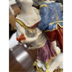 Mid 18th century Meissen figure group, The Tyrolean Dancers, circa 1740, modelled as two swirling figures with their arms linked, he in yellow hat with red rosette, blue jacket, red breeches with red rosette, and yellow shoes with green rosette, she in white blouse with red ribbons, yellow and red bodice, white apron over puce skirt and yellow shoes with green rosettes, her hair fashioned into two plaits secured by red ribbon, upon a shaped mound base, within a scrolling gilt metal mount, with blue crossed swords mark to base, overall H19cm
