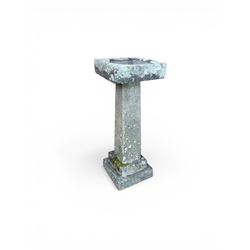 19th century weathered sandstone birdbath, formed in four sections, square top with carved shell bath, raised on tapering column with stepped base
