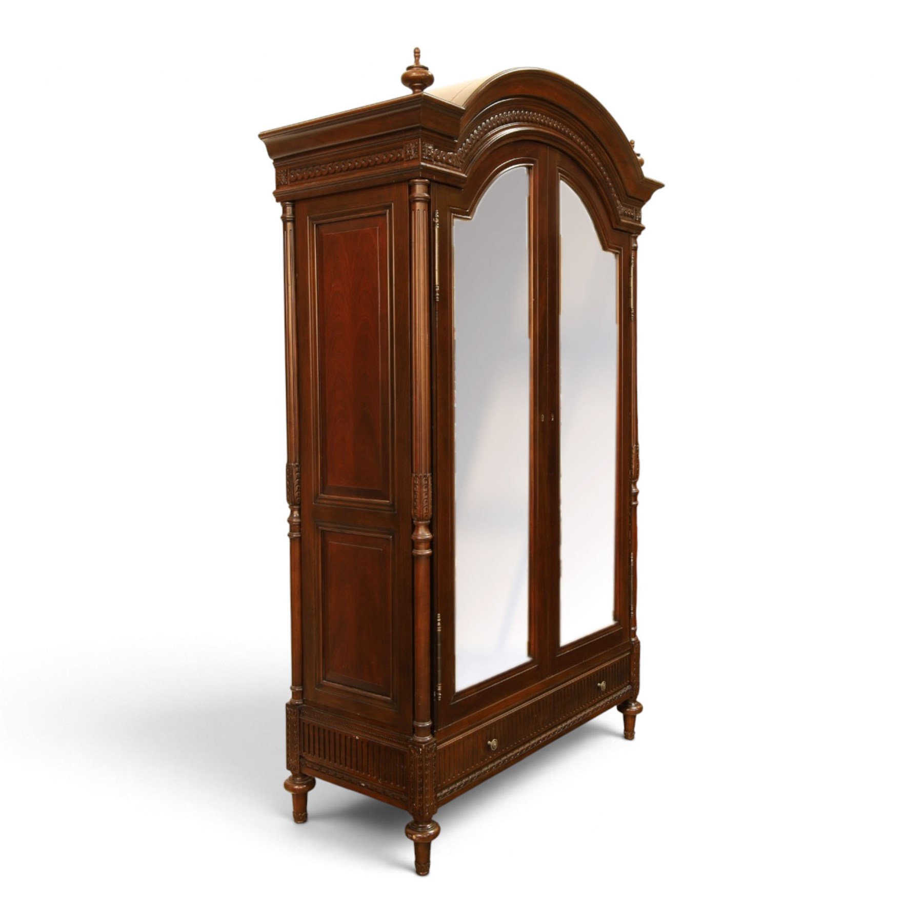 And So To Bed - French design ‘Eclectic’ double wardrobe in dark finish, arched moulded cornice with carved foliate band and turned finials, two mirrored doors enclosing a hanging rail, flanked by turned columns with foliate decoration, single fluted drawer below, on turned tapering feet