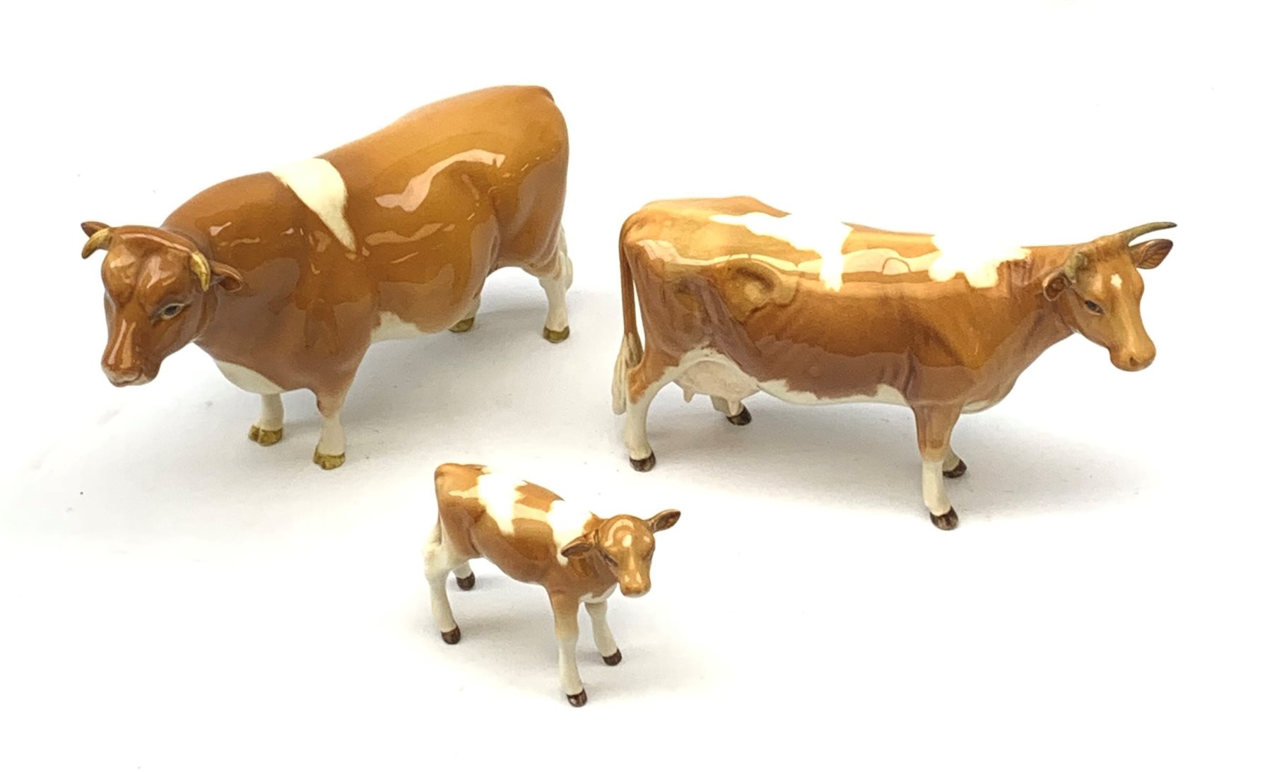 A Beswick Guernsey Bull 1451, marked Ch Sabrina's Sir Richmond 14th, Guernsey Cow, and Guernsey Calf, each with printed mark beneath. 