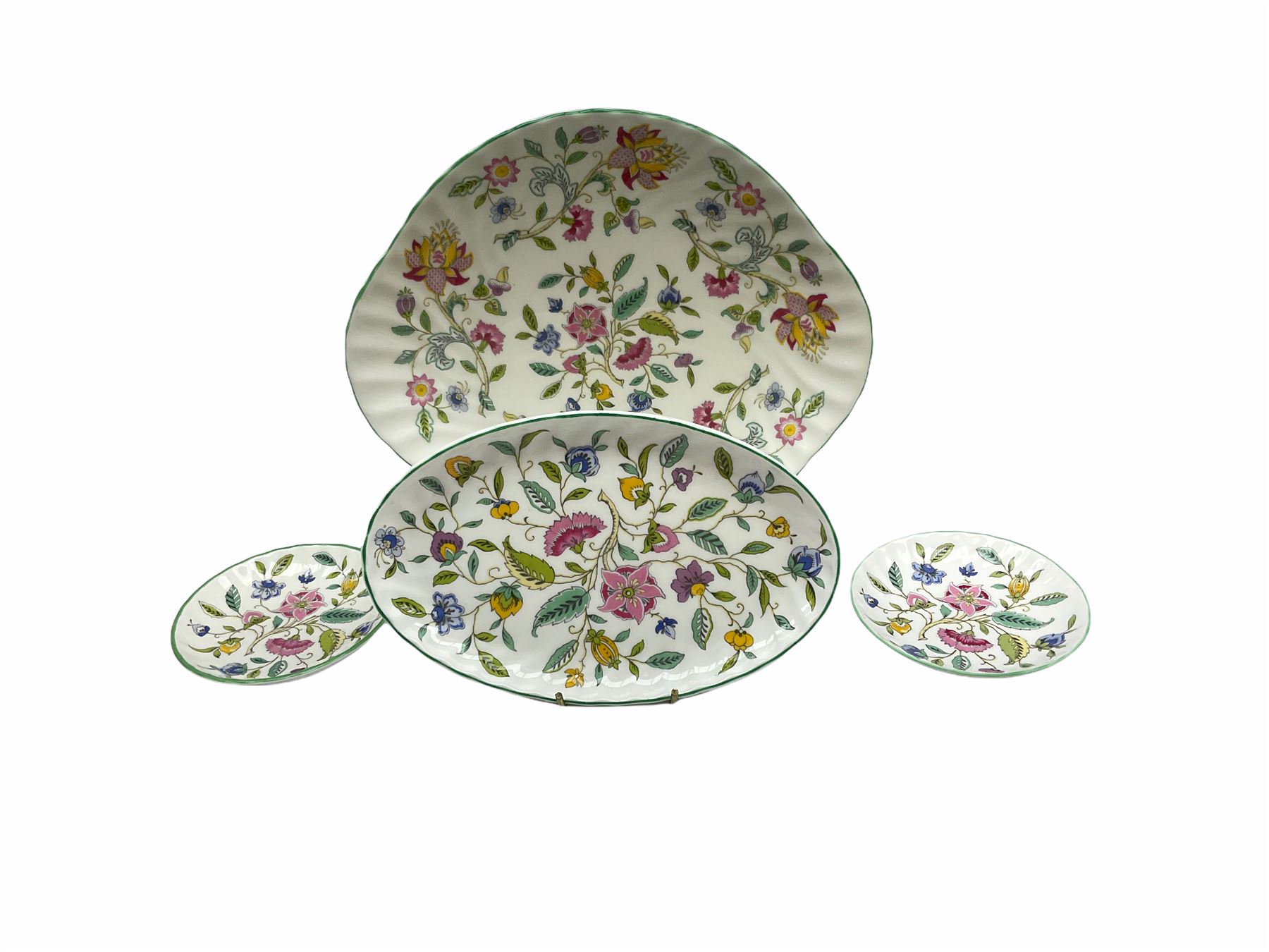 Minton Haddon Hall pattern tea and dinner wares, including basket dish, two covered tureens, six dinner plates, eight dessert plates, twelve tea plates, six soup bowls, six cereal bowls, teapot, coffee pot, milk jug, covered sucrier twelve tea cups and saucers, six mugs, footed bon bon dish, pair of candlestick holders, cake knife and slice etc (81)