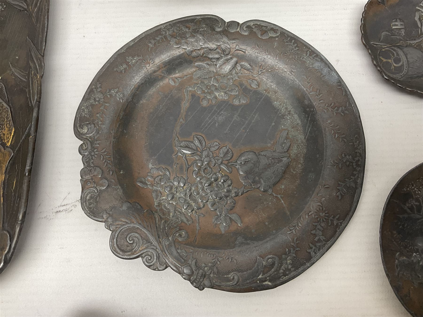 Brass sunfish ashtray, Chinese silver plated trinket box with mirror, bronzed matchbox cover and a collection of other Oriental bronzed embossed metal trays