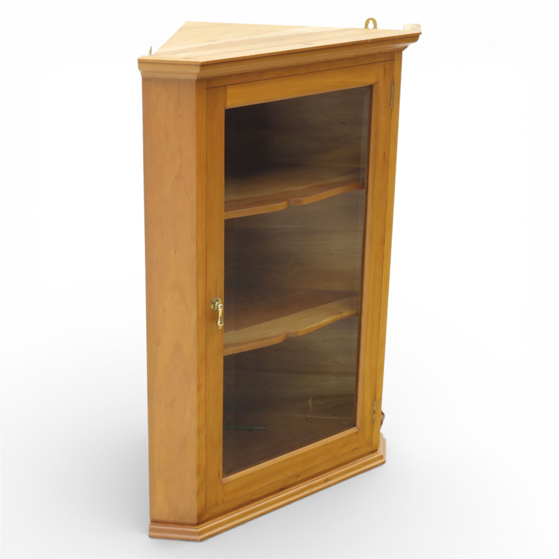 Unicornman - glazed oak corner cabinet, the triangular top with moulded cornice above a bevelled glass door, enclosing two fixed shelves, the canted front corner carved with Unicorn motif, by Geoff Gell of Coxwold