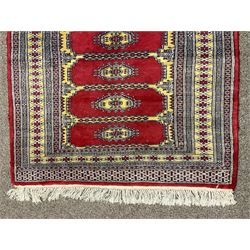 Persian red and yellow ground Bokhara rug, the field with multiple panels each with Gul motif, the five band border decorated with geometric patterns