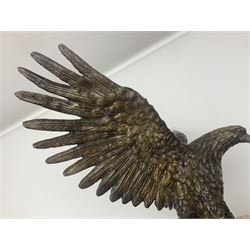 Bronze eagle, modelled in a standing position with wings spread, raised on a black veined marble circular plinth base, H29cm