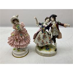 Group of 20th century German figures, to include Muller Volkstedt example of a young girl in pink lace dress adorned with flowers and holding floral bouquet with MV crown mark beneath, together with Volkstedt group figure of dancing courting couple with encrusted flowers, with Vokstedt crown mark beneath, pair of Dresden heavily gilded figures of lady and gentleman holding bouquets  on ornate plinth bases and furhter pair of figures in blue dress with D crown mark beneath