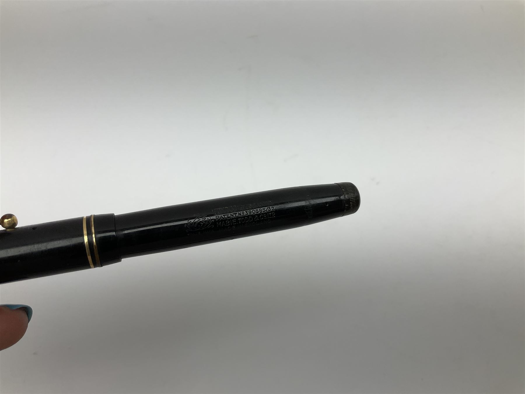 Vintage Swan Mabie Todd lever fill fountain pen in coral red, the nib a/f marked 14K, together with two further vintage Swan Mabie Todd fountain pens, the first example with lever fill, the other leverless, each with black body, one with nib marked 14ct, (3) 