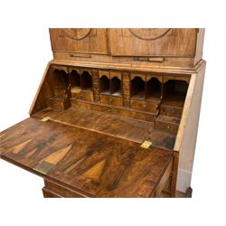 18th century walnut bookcase on bureau, the bookcase with sloped top pediment over two panelled doors and candle slides, fitted with two adjustable shelves and pigeon holes, the bureau with fall front enclosing a well fitted interior, with a combination of pigeon holes, drawers and secret compartments, fitted with two small and four long graduating drawers, on bracket feet