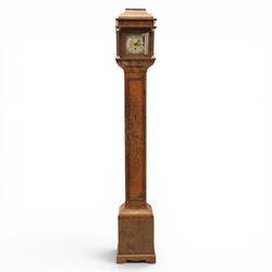 Early 20th century walnut small longcase clock, brass dial with silvered Roman numeral chapter ring and pierced black hands, the figured walnut case with shaped projecting hood, long moulded trunk door and stepped plinth base