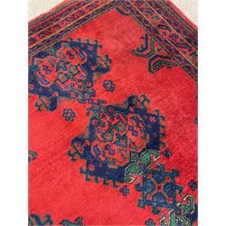 Turkish red ground rug, red ground with quadruple stylised geometric medallions, multi-band border