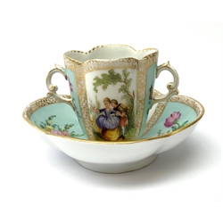 A Helena Wolfsohn Dresden porcelain quatrefoil twin handled chocolate cup and stand, painted with panels of courting figures and floral sprays upon a light blue ground, each with painted mark beneath, saucer L14.5cm, cup H8cm. 