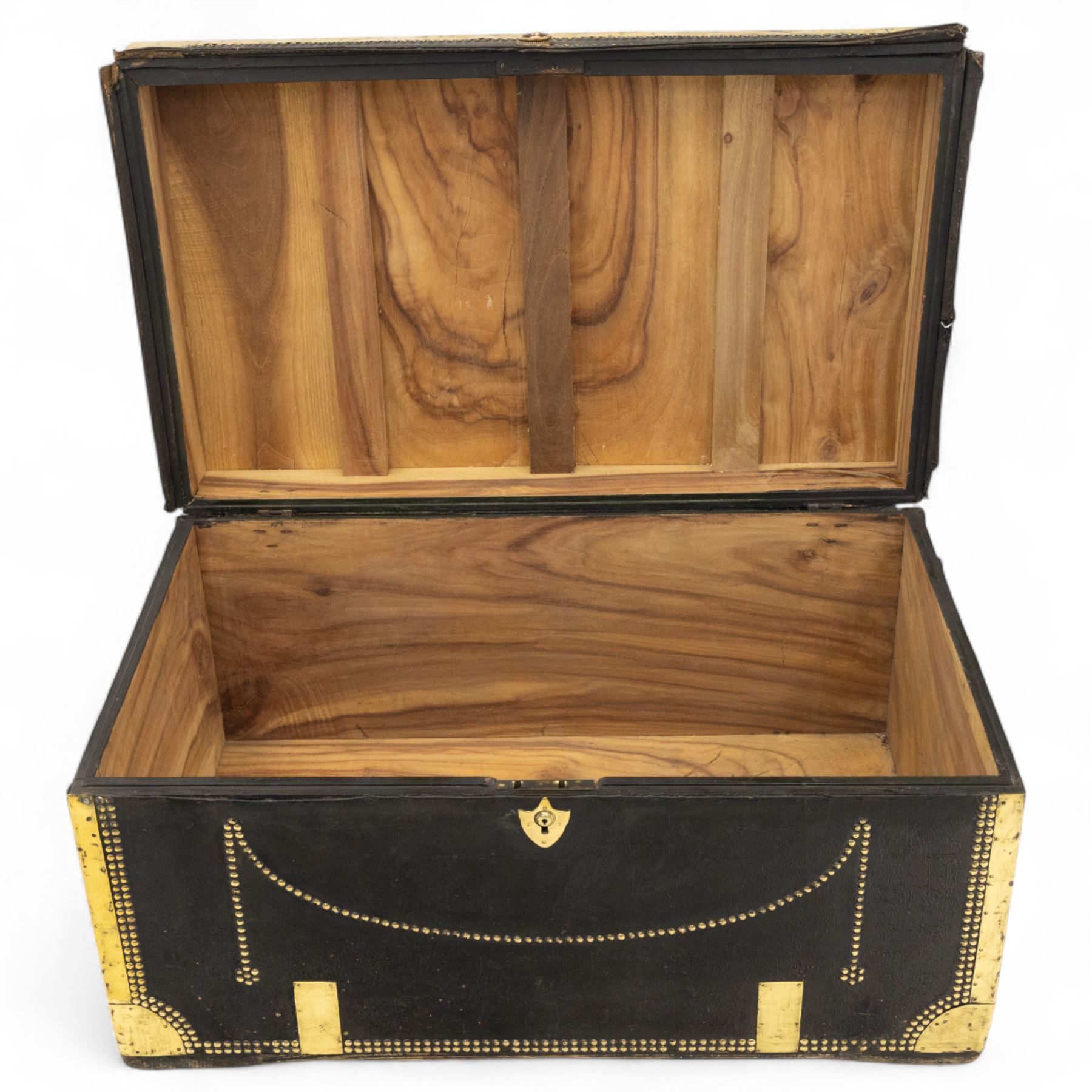 An early 19th-century Georgian brass-bound travelling trunk, leather-covered exterior with brass stud work decoration, front with central brass lock plate, hinged lid with camphor wood interior, external sides fitted with large brass carrying handles 