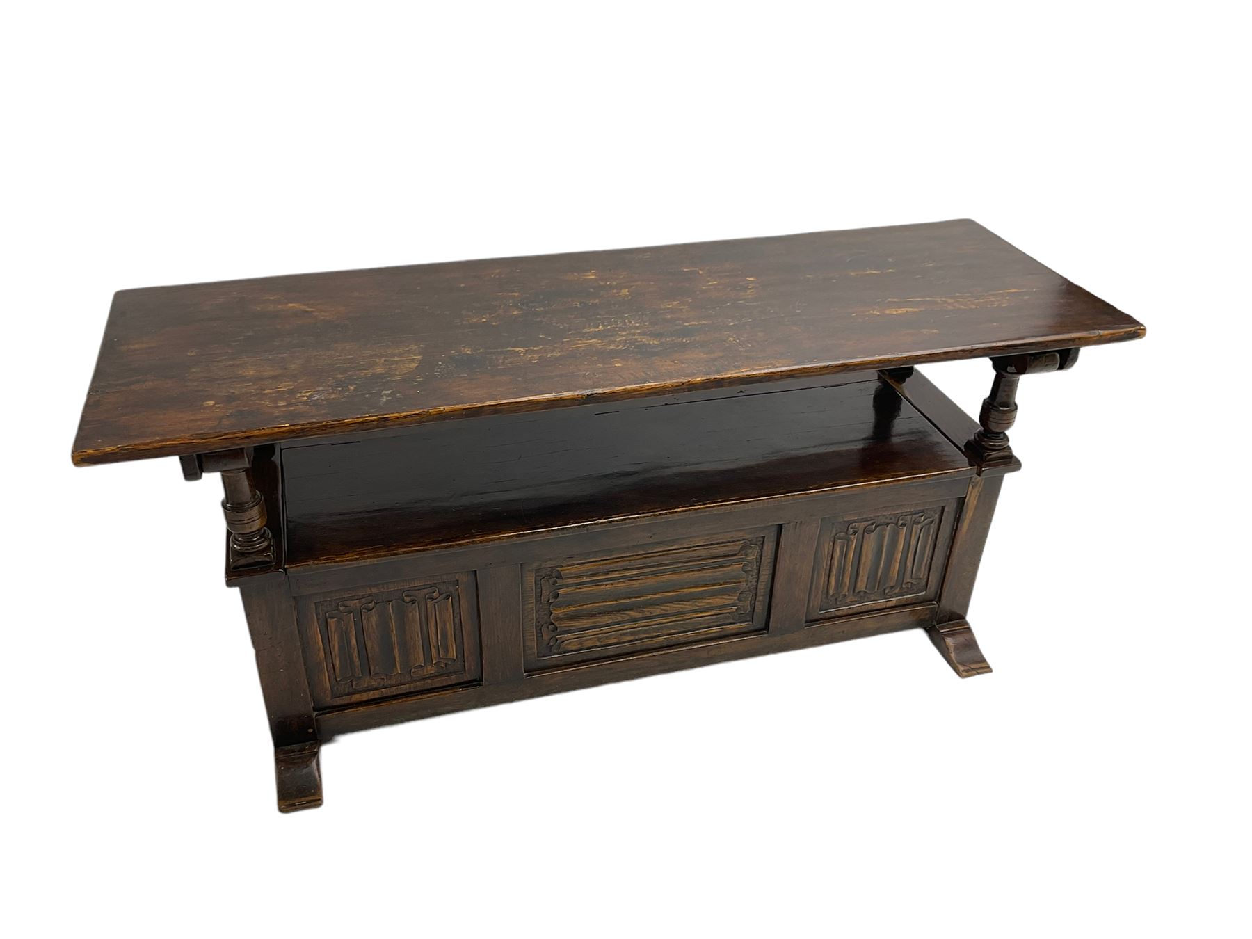 Jacobean design oak Monks bench, the front with carved linenfold panels, hinged metaphoric table back, hinged box seat compartment, on sledge feet