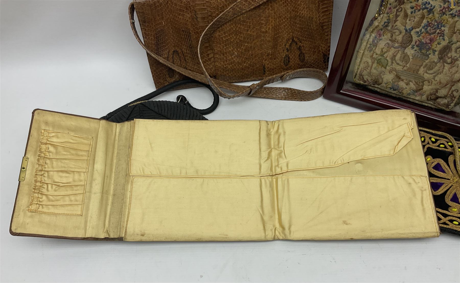 Continental petit point evening bag, with enamel and pearl details, in wooden display frame, together with a snake skin handbag and three other vintage bags